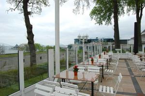eine Reihe von Tischen und weißen Stühlen auf einer Terrasse in der Unterkunft Pension Radke in Heringsdorf