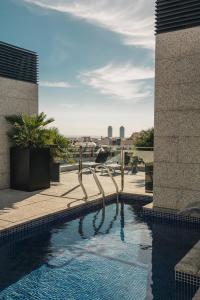 a swimming pool on the roof of a building at Suites Avenue in Barcelona