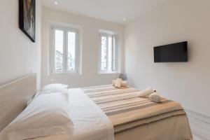 a white room with a bed with a flat screen tv at Masai - One bedroom flat 1st floor by train station in Florence