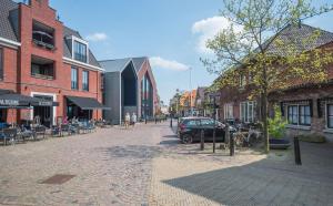 a cobblestone street in a city with a car parked at vakantiewoning Stadszicht in Ootmarsum