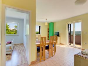 a dining room and living room with a table and chairs at Apartments Truške in Truške