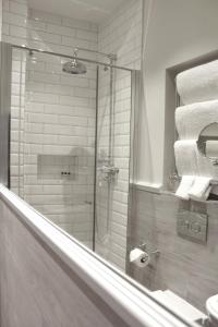 a bathroom with a shower and a toilet and towels at The Grafton Arms Pub & Rooms in London