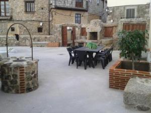 patio ze stołem i krzesłami na dziedzińcu w obiekcie Casa Rural Menta y Canela w mieście Tórtoles