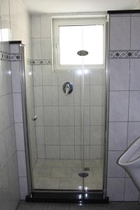 a shower with a glass door and a window at Familienfreundliche Ferienwohnung für 4 Personen in Lutzerath +23 photos