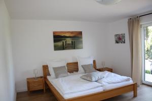 a bed with white sheets and pillows in a room at Familienfreundliche Ferienwohnung für 4 Personen in Lutzerath