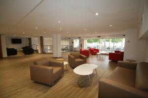 a lobby with couches and chairs and a table at Hotel Vela in Roses