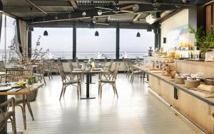 a restaurant with tables and chairs and windows at Hotel Villa Rosario, Palacete in Ribadesella