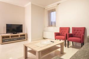 Sala de estar con 2 sillas rojas y TV en Luxury Apartments Villa Matea 1, en Malinska