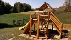 a wooden play structure with a roof on top at Tourist Farm Rajšp in Benedikt v Slovenskih Goricah