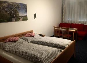 a bedroom with two beds and a table and a table at Hotel - Landgasthof Winklehner in Sankt Pantaleon-Erla