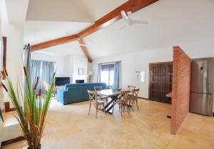 a living room with a table and chairs and a blue couch at El Capricho Villa Rural Caminito del Rey in Alora