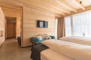 Un dormitorio con una cama y un televisor en una pared. en Hotel Garberhof, en Malles Venosta 85 fotos más