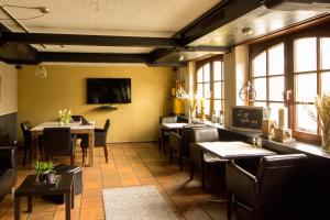 uma sala de jantar com mesas, cadeiras e janelas em Landhotel Wolfschlugen em Wolfschlugen