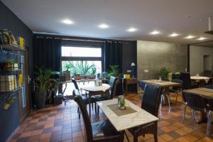 a restaurant with tables and chairs and a window at Landhotel Wolfschlugen in Wolfschlugen