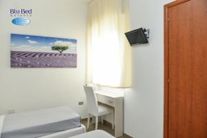 a bedroom with a bed and a desk with a computer at Blu Bed Salento in Torre Lapillo
