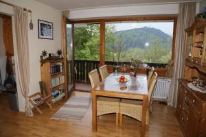 a dining room with a table and a large window at Ferienwohnung Ackermann Oberallgäu in Missen-Wilhams