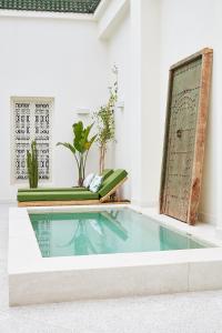 Numa Marrakech في مراكش: مسبح في غرفة بها نباتات ومرآة