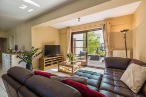 ein Wohnzimmer mit einem Sofa und einem TV in der Unterkunft Brussels Expo Terrace Residence in Wemmel