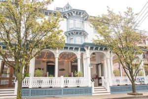 a blue and white house with a white gazebo at The Carroll Villa Hotel in Cape May