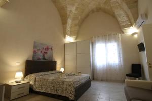 Schlafzimmer mit einem Bett und einem Fenster in der Unterkunft Corte Manzoni in Melendugno