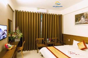 a hotel room with a bed and a desk with a desk at Hai Tien Plaza Hotel in Mỹ Ðuc