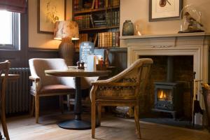 a living room with a table and a fireplace at Wynnstay Arms, Ruabon, Wrexham in Ruabon