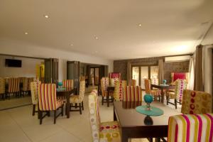 a dining room with tables and chairs in a restaurant at Gecko Inn in Richards Bay