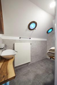 een badkamer met een witte wastafel en een spiegel bij Boutique Appartments AlteGreißlerei in St. Wolfgang