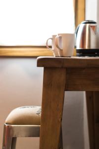 een houten tafel met een waterkoker en een kopje erop bij B&B L'Eroico in Gaiole in Chianti