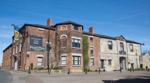 un grand bâtiment en briques au coin d'une rue dans l'établissement Wynnstay Arms, Ruabon, Wrexham, à Ruabon