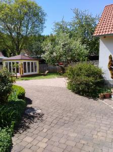 a yard with a house and a brick driveway at Ferienhaus Kaiser in Branchewinda