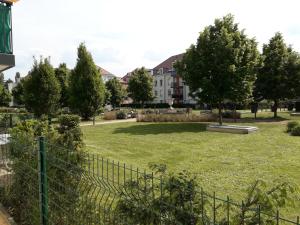 コルマールにあるRésidence Le Parc COLMARの塀と木々のある公園と建物