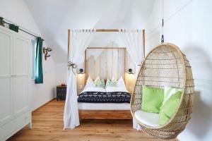 a room with a bed with a hanging chair at Boutique Appartments AlteGreißlerei in St. Wolfgang