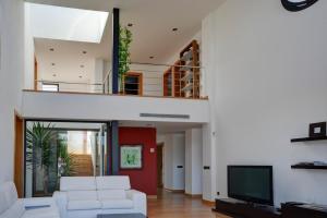 a living room with a white couch and a tv at Can miami modern house close platja den bossa in Sant Jordi