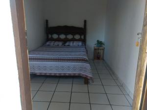a bedroom with a bed and a tiled floor at Pousada Maia in Itaúnas