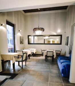 un comedor con mesas y un sofá azul en Samsara Hotel Salta en Salta
