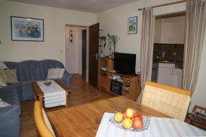 a living room with a table with a bowl of fruit on it at Ferienwohnung Ackermann Oberallgäu in Missen-Wilhams