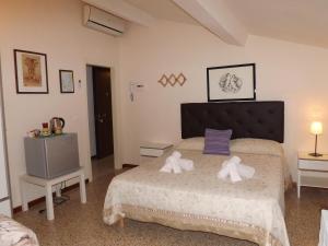 1 dormitorio con 1 cama con 2 toallas en B&B Central Toma, en Montecatini Terme