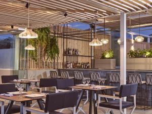 a restaurant with wooden tables and chairs and lights at Hotel St.John Suites Adults Only in Tsilivi