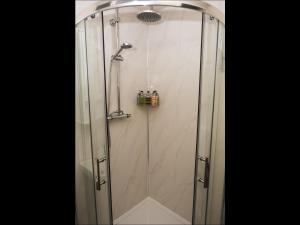 a shower with a glass door in a bathroom at Cedar Apartment in Helensburgh
