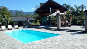 een zwembad voor een huis bij Pousada Rancho do Nhesko in Garuva