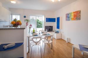 a kitchen and dining room with a table and chairs at Apartments Stasic in Vrbnik