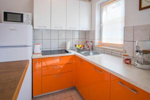 a kitchen with orange cabinets and a white refrigerator at Apartments Stasic in Vrbnik