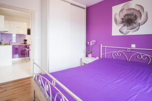 a purple bedroom with a bed with a purple wall at Apartments Stasic in Vrbnik