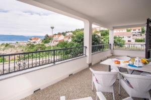 a balcony with a table and chairs and a view at Apartments Stasic in Vrbnik