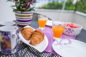 a table with plates of pastries and glasses of orange juice at Apartments Stasic in Vrbnik