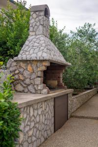 an outdoor stone oven in a stone wall at Apartments Stasic in Vrbnik
