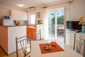 a kitchen and dining room with a table and chairs at Apartments Stasic in Vrbnik