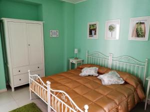 una camera da letto con un grande letto con pareti verdi di La Ginestra a Sirolo