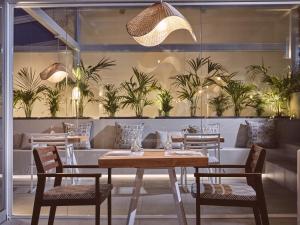 a restaurant with a table and chairs and plants at Hotel St.John Suites Adults Only in Tsilivi